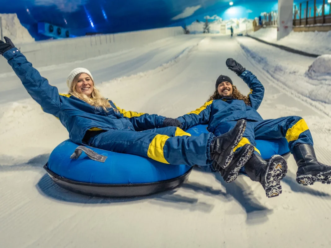 Casal se divertindo no tubing (boia) na neve do Snowland em Gramado